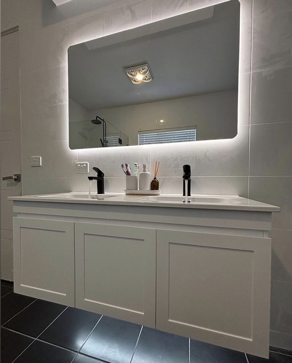 Backlit bathroom mirror and vanity lighting installation
