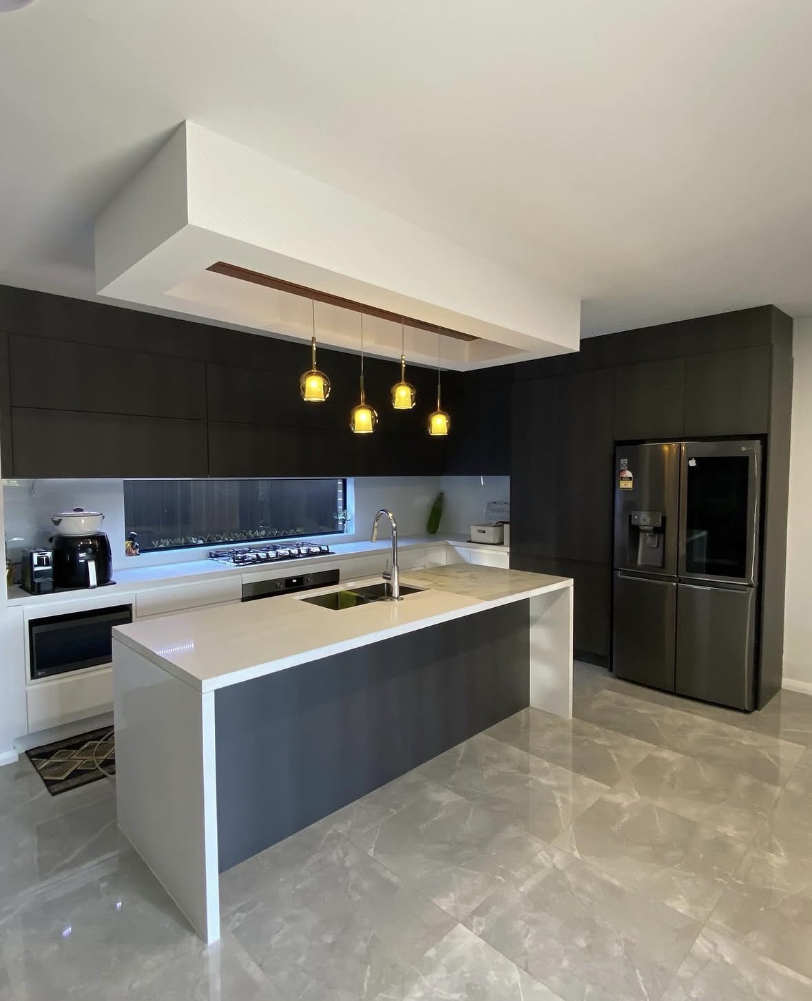 Modern dark kitchen with pendant lights and LED strip lighting
